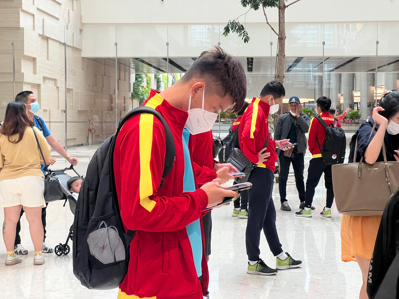 Hầu hết các cầu thủ đều tập trung vào điện thoại của mình.