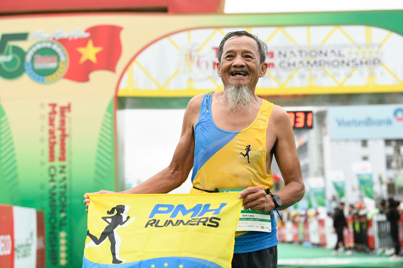 Chú Lương sung sướng trên vạch đích với lá cờ của Phú Mỹ Hưng Runner. (Ảnh: Dương Triều)