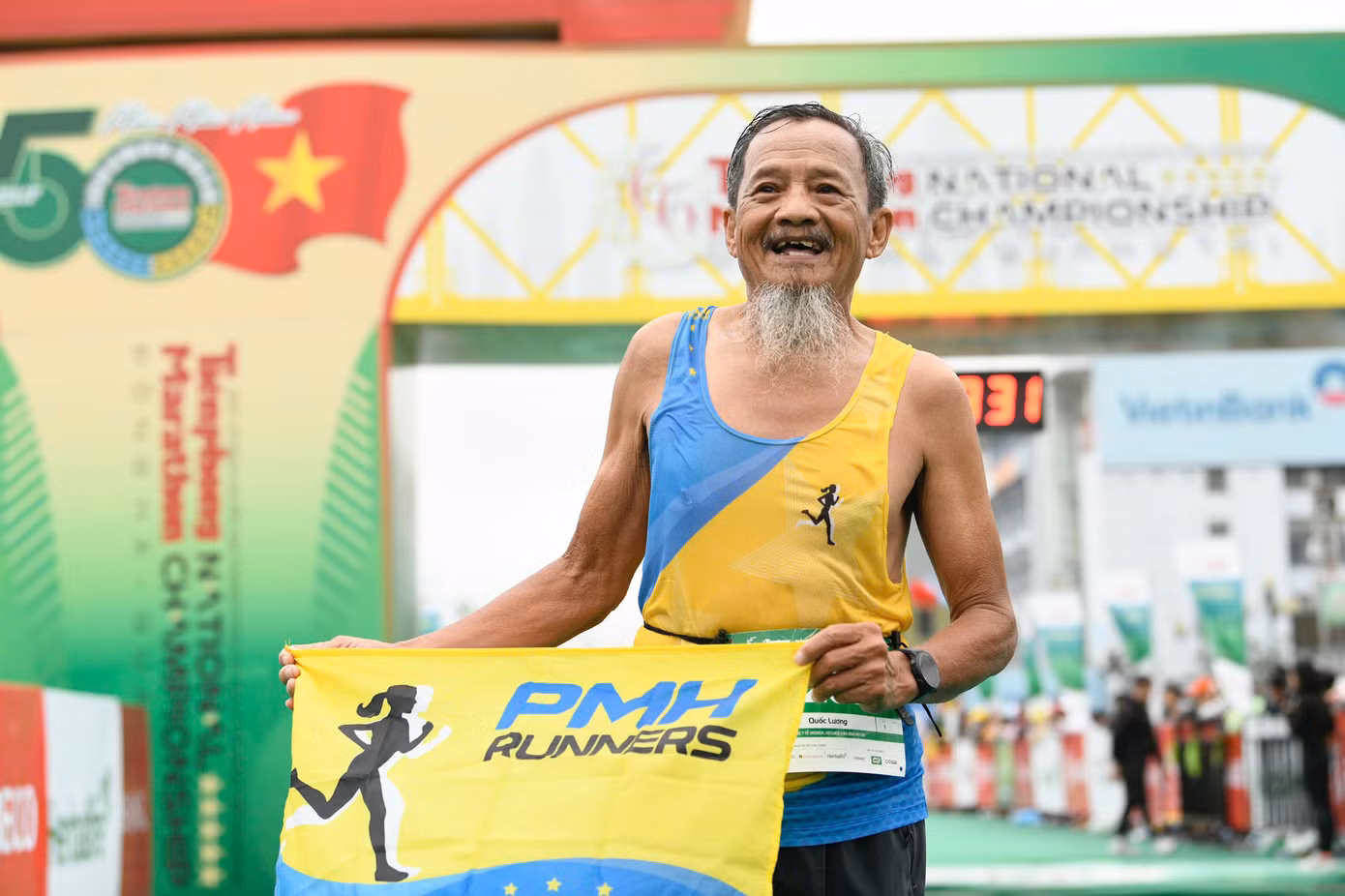 Chú Lương sung sướng trên vạch đích với lá cờ của Phú Mỹ Hưng Runner. (Ảnh: Dương Triều)