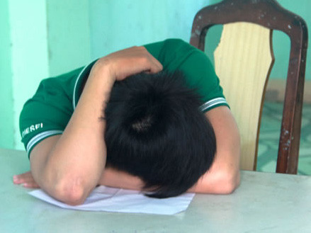 Thành gục mặt tại trụ sở công an. Ảnh: CAĐN