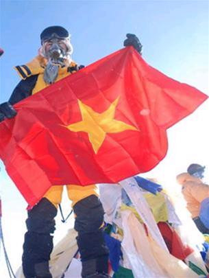 Bùi Văn Ngợi với lá cờ Tổ quốc trên đỉnh Everest lúc 7g15 sáng 22-5-2008. Ảnh: Bradley Clement (Tuổi trẻ).