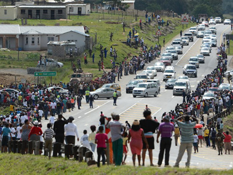 Linh cữu của cố tổng thống Nam Phi được đưa bằng máy bay về quê nhà ở ngôi làng Qunu, tỉnh Đông Cape, vào hôm qua. Rất đông người dân địa phương đứng hai bên đường để chờ đợi với hy vọng được nhìn thấy quan tài mang thi hài ông lần cuối