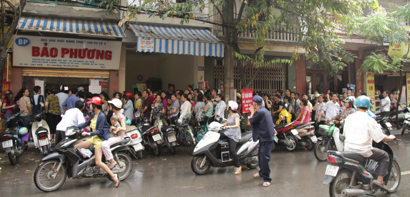 Đoàn người rồng rắn, nối đuôi nhau xếp hàng trên vỉa hè chờ tới lượt mua bánh. Ảnh: Trường Phong