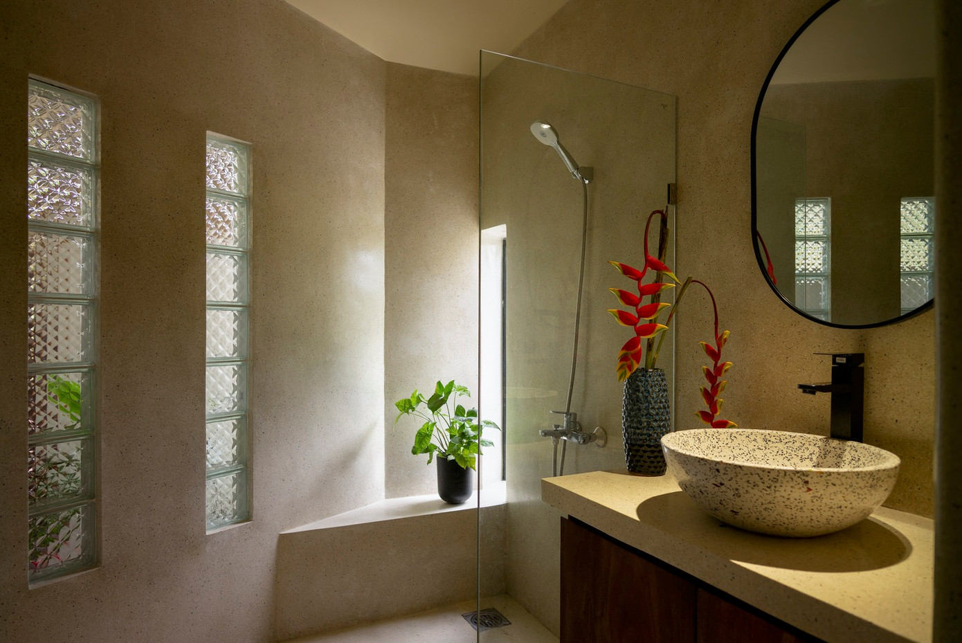 Các không gian chính tiếp cận trực tiếp với không gian ngoài trời thông qua các ô cửa và cửa sổ lớn, mang đến cảnh quan xanh tràn đầy sức sống và đón ánh sáng tự nhiên, cùng với khung cảnh nhìn ra cánh đồng lúa xanh và rừng cây tươi tốt.