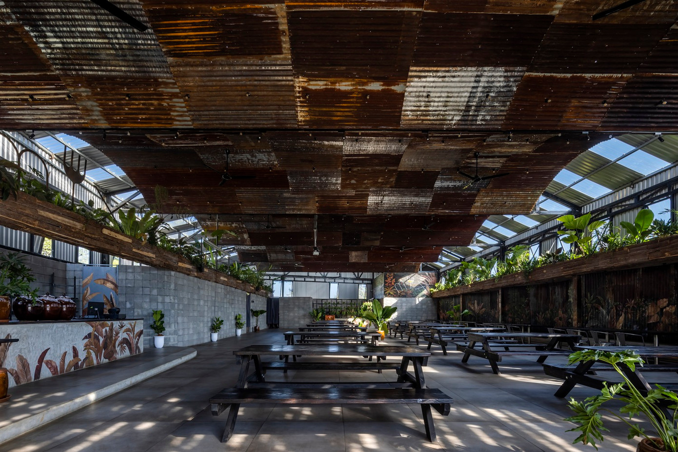 Khu vực ăn uống trong nhà được thiết kế với phần mái tôn cách nhiệt kết hợp hệ trần trang trí cũ kĩ, hệ thống phun sương ẩn nấp khéo léo trên mái và mảng cây cối được treo lên để giảm nóng đồng thời tăng cảm giác mới mẻ cho thực khách để tạo điểm thu hút riêng biệt cho khu vực này.