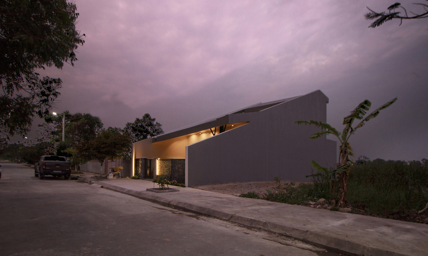 Mái dốc kéo dài từ mặt đất lên tầng 1, hiên rộng và cổng thấp tạo cảm giác về ngôi nhà một tầng truyền thống ở vùng quê Việt Nam. Mái dốc kéo dài từ mặt đất lên tầng 1, hiên rộng và cổng thấp tạo cảm giác về ngôi nhà một tầng truyền thống ở vùng quê Việt Nam.