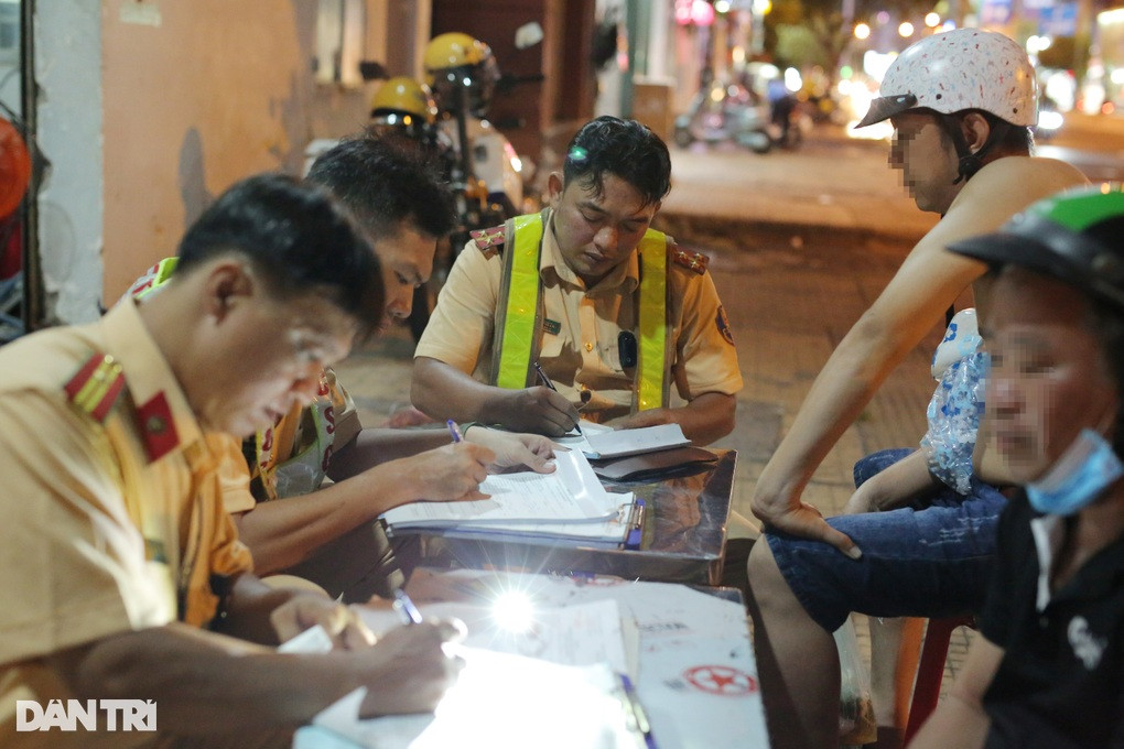 Tài xế H. (đội nón bảo hiểm màu trắng) bị CSGT lập biên bản xử phạt (Ảnh: An Huy). Tài xế H. (đội nón bảo hiểm màu trắng) bị CSGT lập biên bản xử phạt (Ảnh: An Huy).