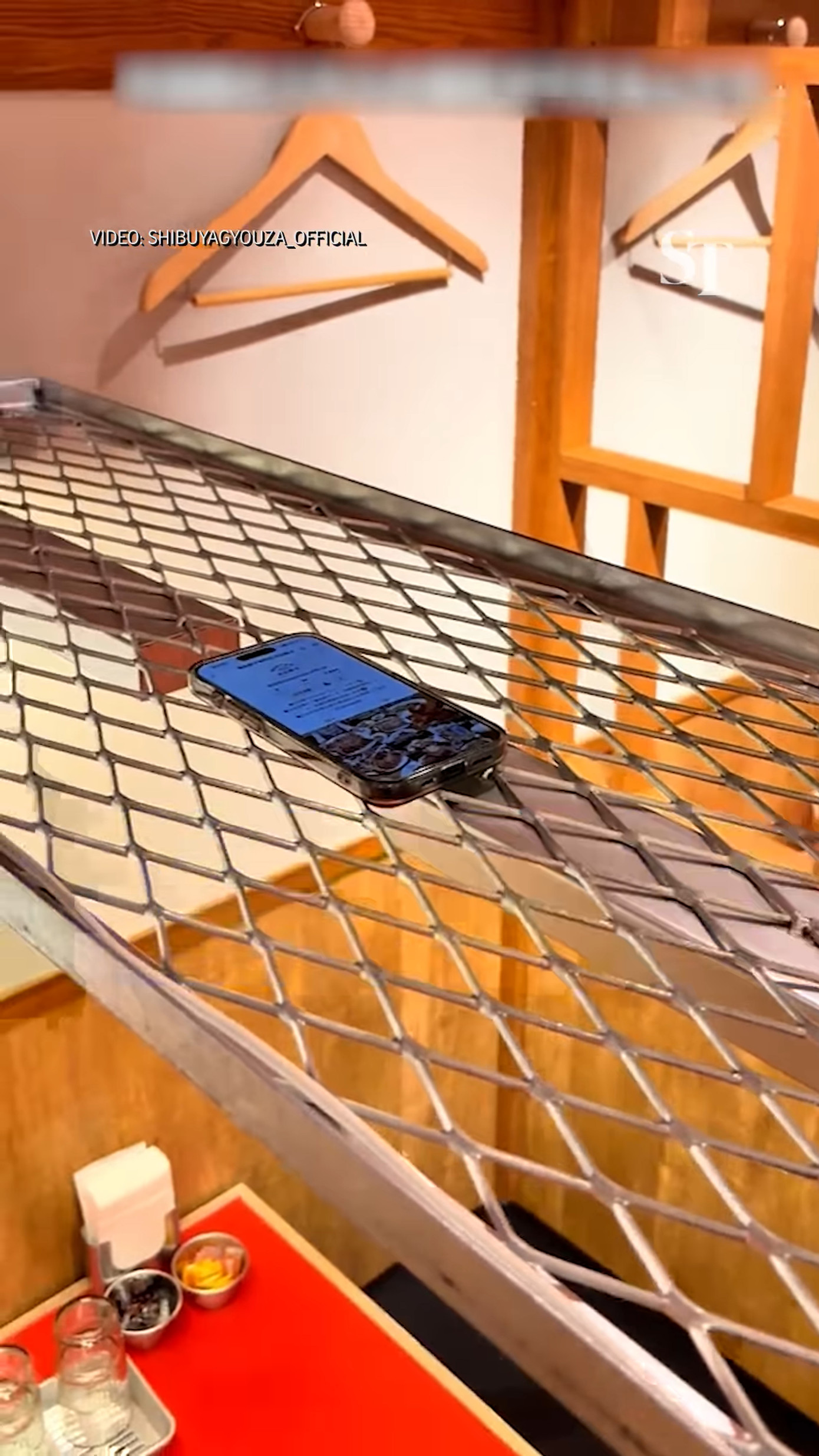 Nhiều người cho rằng đặt điện thoại trên phần giá lưới sẽ an toàn hơn vì tránh được tình huống bị đổ nước vào điện thoại khi ăn. Ảnh: @straitstimesonline Nhiều người cho rằng đặt điện thoại trên phần giá lưới sẽ an toàn hơn vì tránh được tình huống bị đổ nước vào điện thoại khi ăn. Ảnh: @straitstimesonline