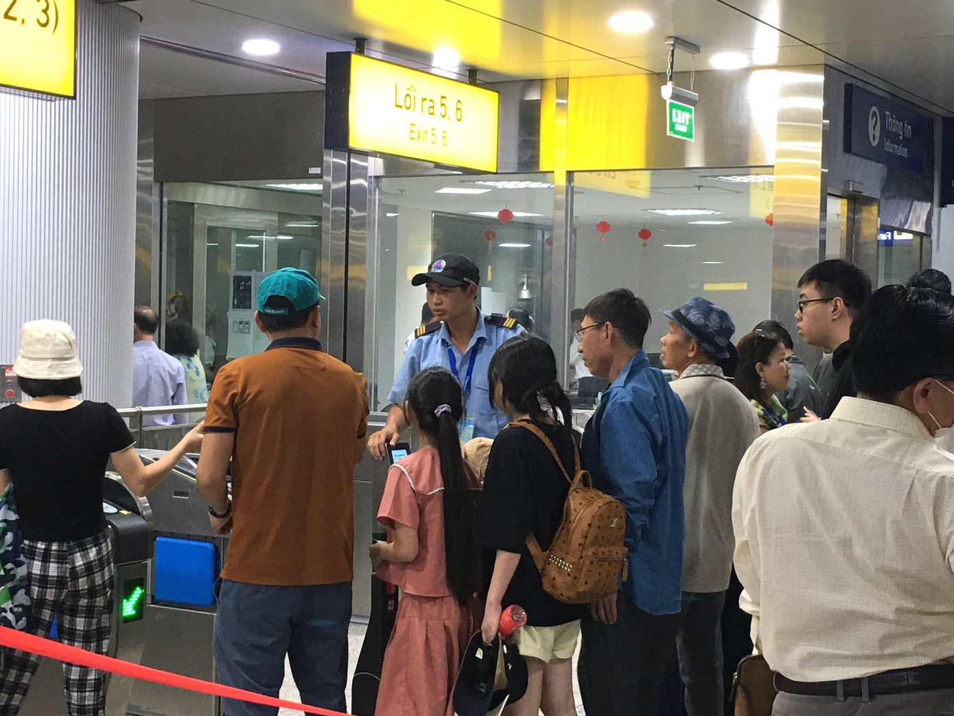 Nhân viên trực hỗ trợ người dân qua cổng soát vé.