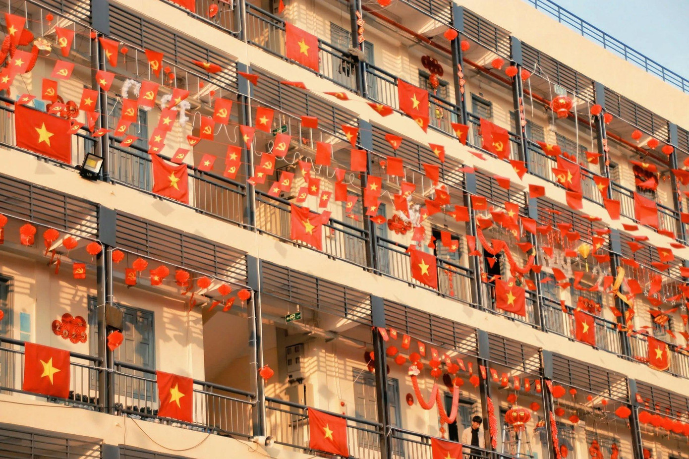 Dưới ánh nắng vàng, sắc đỏ của cờ, của những chiếc lồng đèn càng thêm rực rỡ.