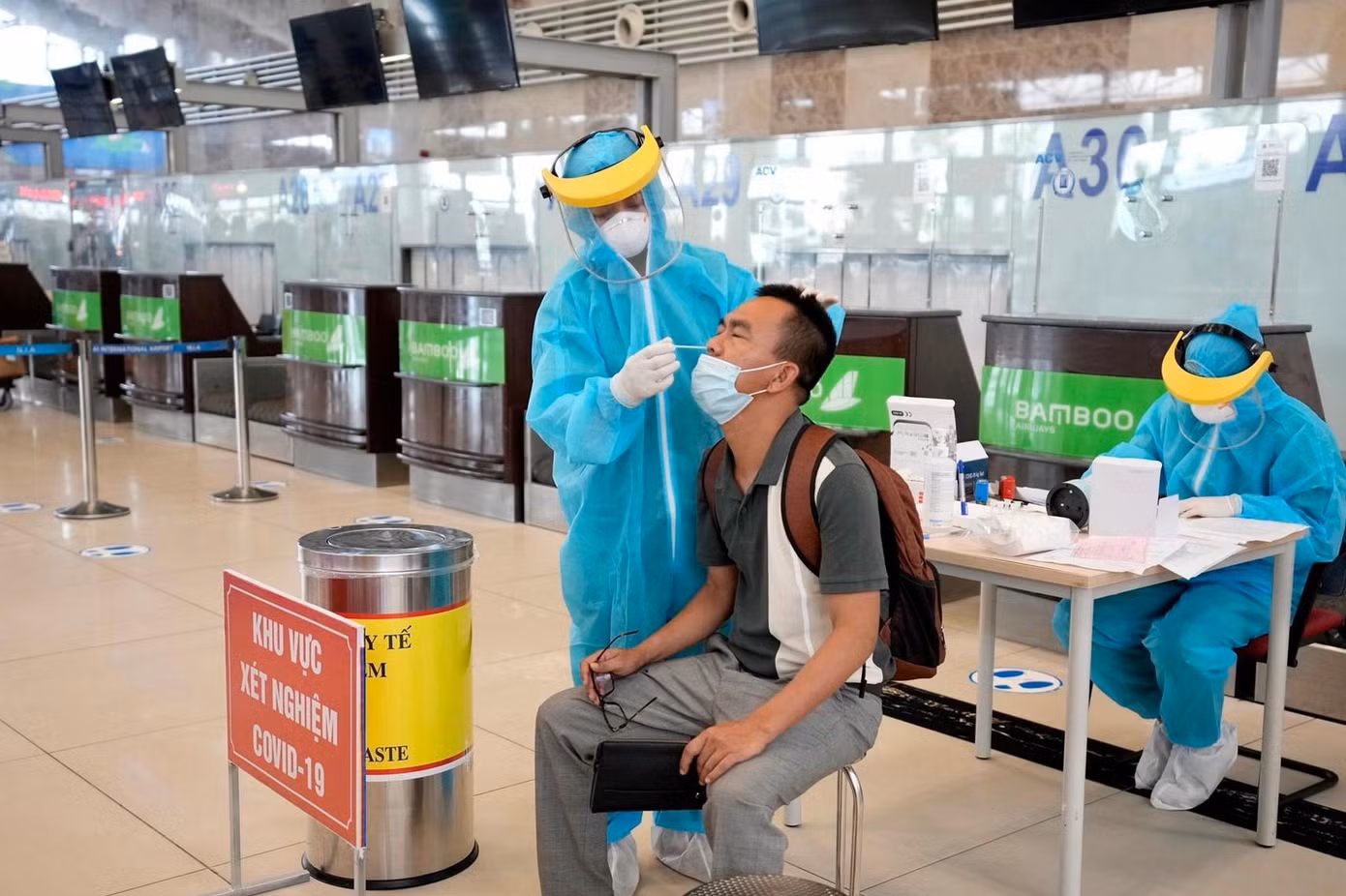 Nhân viên y tế lấy mẫu xét nghiệm hành khách nhập cảnh qua sân bay Tân Sơn Nhất