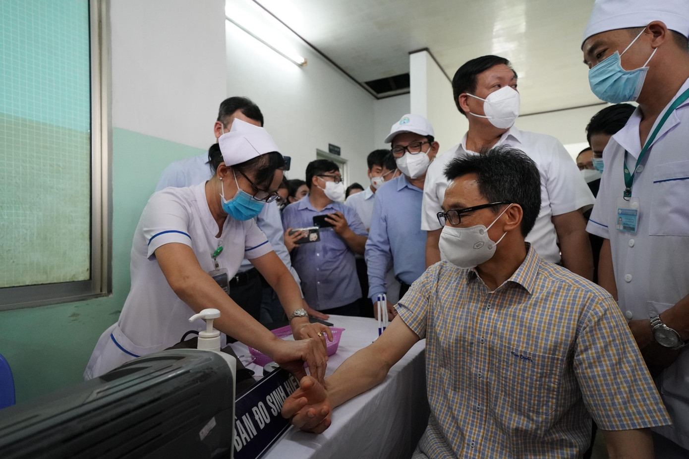 Nhân viên y tế đo huyết áp, kiểm tra sức khỏe Phó Thủ tướng Vũ Đức Đam trước khi tiêm chủng Nhân viên y tế đo huyết áp, kiểm tra sức khỏe Phó Thủ tướng Vũ Đức Đam trước khi tiêm chủng