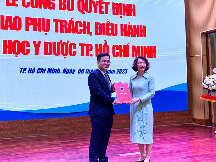 Bà Nguyễn Thị Liên Hương, thứ trưởng Bộ Y tế, trao quyết định cho ông Ngô Quốc Đạt (Ảnh: Trần Huỳnh)