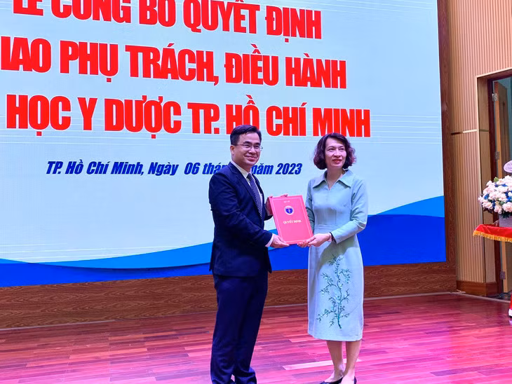 Bà Nguyễn Thị Liên Hương, thứ trưởng Bộ Y tế, trao quyết định cho ông Ngô Quốc Đạt (Ảnh: Trần Huỳnh)