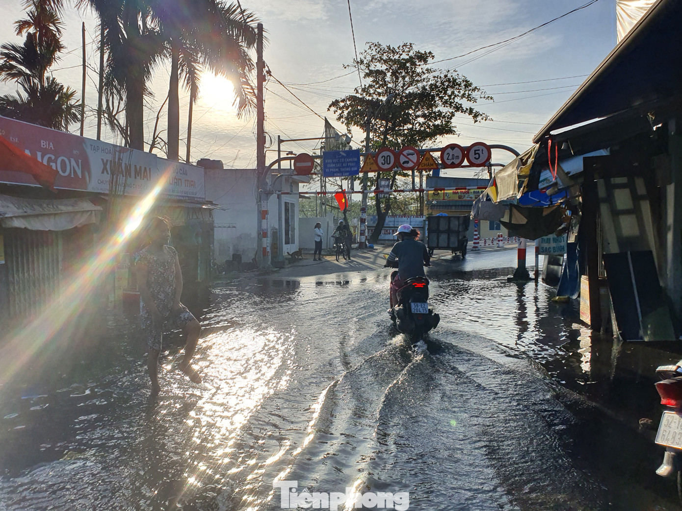 Người dân lội nước bẩn du xuân sáng mùng 4 Tết. Trước đó vào tối mùng 3, nhiều nơi tại TPHCM cũng đón một cơn mưa lớn và giông lốc mạnh
