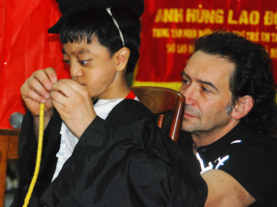 Erix Logan bình dị khi trình diễn ảo thuật với một em bé khuyết tật tại Trung tâm nuôi dưỡng trẻ Tam Bình- TPHCM