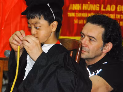 Erix Logan bình dị khi trình diễn ảo thuật với một em bé khuyết tật tại Trung tâm nuôi dưỡng trẻ Tam Bình- TPHCM