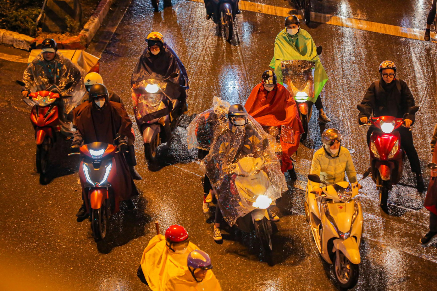 Các phương tiện chờ đèn đỏ trong cơn mưa rét.