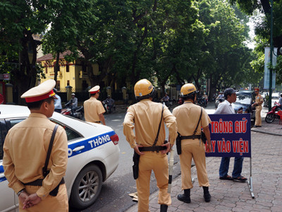 ất nhiều CSGT vây 1 chiếc xe biển xanh dừng đỗ không đúng quy định trên đường Nguyễn Thái Học