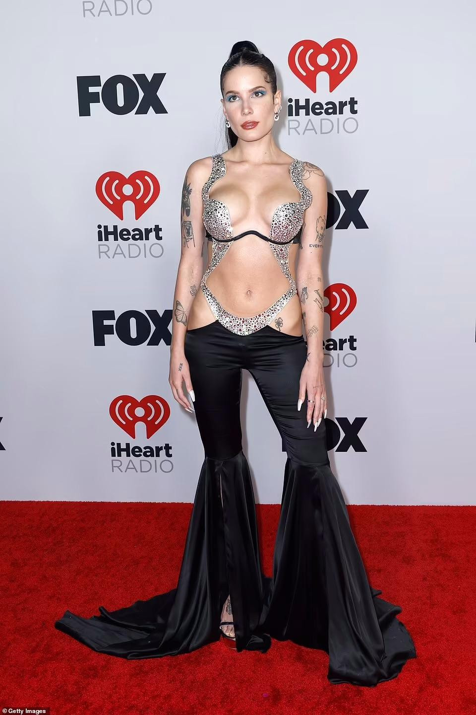 Halsey gây choáng váng khi xuất hiện trên thảm đỏ trong bộ đồ liền thân hở bạo. Thân trên thiết kế "tiết kiệm vải" chỉ đủ che bộ phận nhạy cảm nhất. Phần quần ống loe giúp người đẹp trông cao hơn nhiều so với chiều cao thực là 1m63.