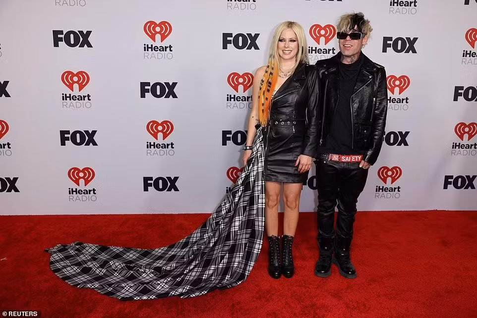 "Công chúa nhạc punk" Avril Lavigne sánh đôi cùng bạn trai Mod Sun. Bộ đồ da kết hợp với vải hoạ tiết caro bị nhận xét là "dìm" dáng nữ ca sĩ 38 tuổi.