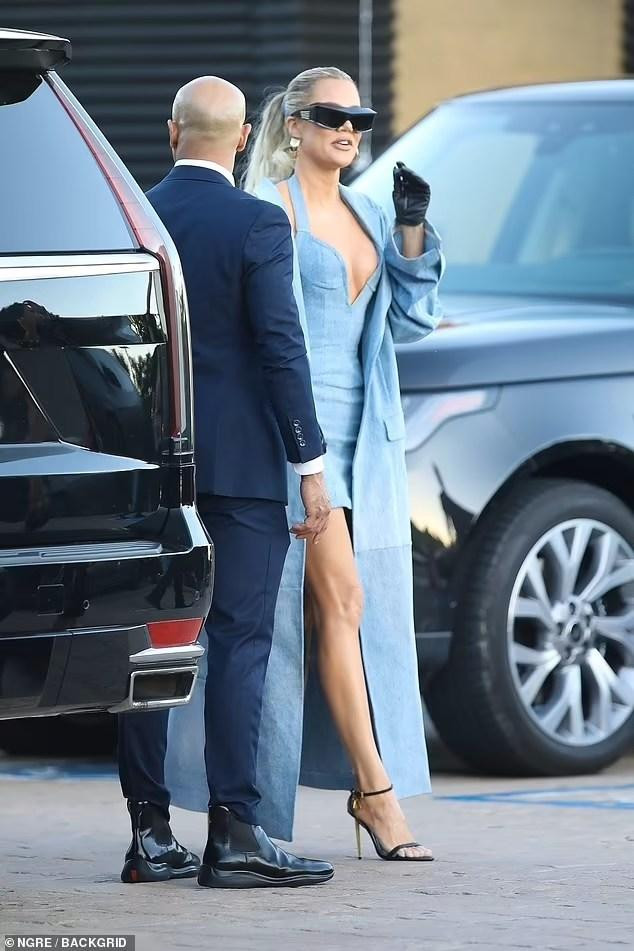 Là chủ nhân bữa tiệc, Khloe nổi bật hơn hẳn em gái siêu mẫu. Cô diện nguyên cây denim xanh bắt mắt, với váy hai dây ngắn xẻ ngực sâu và áo khoác dáng dài. Người đẹp đeo kính và bông tai bản to, kèm theo găng tay da đen và sandal cao gót cùng màu.
