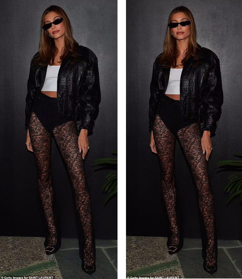 Hailey Bieber khoe đôi chân dài với đôi tất lưới ren lộ nội y đen táo bạo. Bên trên mặc áo crop-top trắng phối với áo khoác da và mắt kính đen trông vừa sexy, vừa cá tính, bụi bặm.