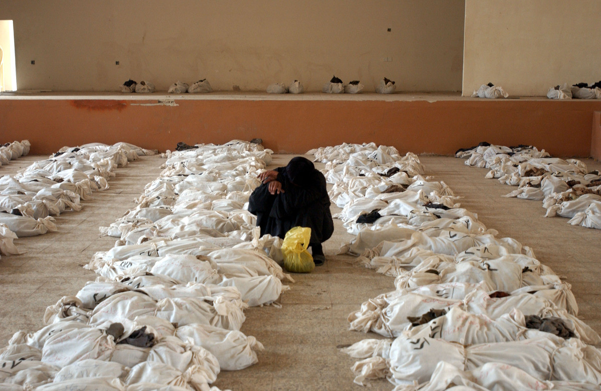 Một phụ nữ Iraq khóc bên thi thể người thân. Các thi thể được đưa lên từ một ngôi mộ tập thể ở ngoại ô Al Musayyib, cách Baghdad 50 km về phía nam, ngày 27-5-2003