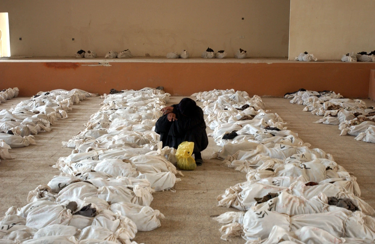 Một phụ nữ Iraq khóc bên thi thể người thân. Các thi thể được đưa lên từ một ngôi mộ tập thể ở ngoại ô Al Musayyib, cách Baghdad 50 km về phía nam, ngày 27-5-2003