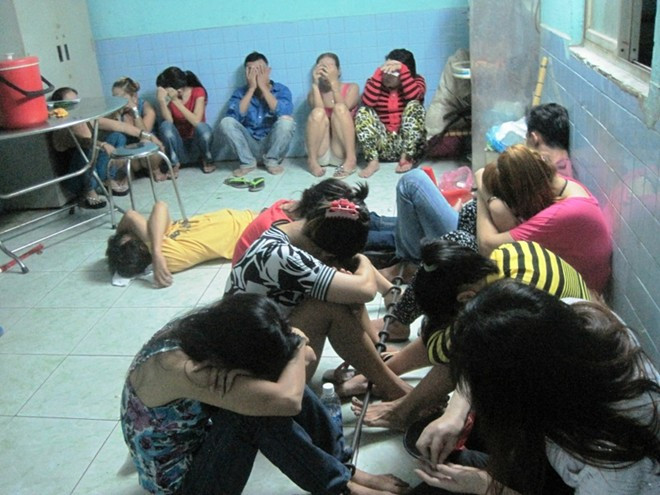 Bà Lý (60 tuổi, người mặc áo vàng kẻ ngang) cùng các gái mại dâm bị công an bắt quả tang 