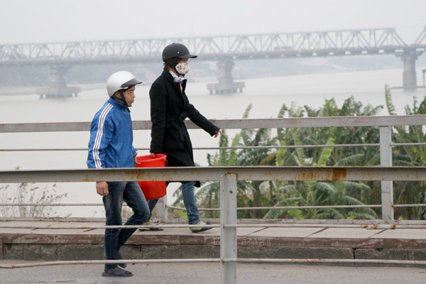 Khiêng cả xô cá đi phóng sinh tại khu vực cầu Long Biên