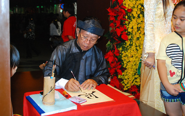 Bên trong đường sách, Ông Đồ già thì cho chữ 