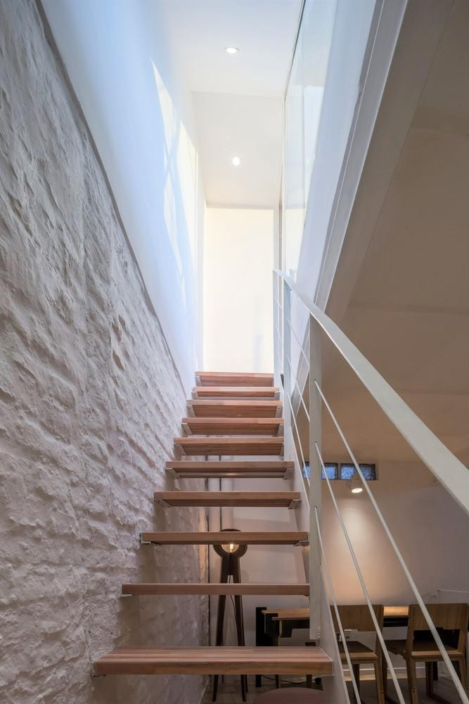 Theo đó, cả nhà kho được sơn lại màu trắng, một chiếc cầu thang nối liền tầng trệt với gác lửng và thông lên khu vườn trên sân thượng.