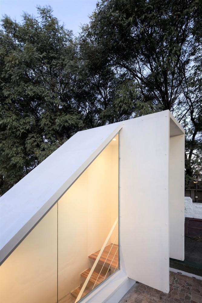 Phần cầu thang dẫn lên sân thượng có một bên lắp kính trong để lấy ánh sáng tự nhiên cho ngôi nhà. Cửa sân thượng khá nhỏ và luôn được mở để thông khí cho nhà như quạt thông gió.