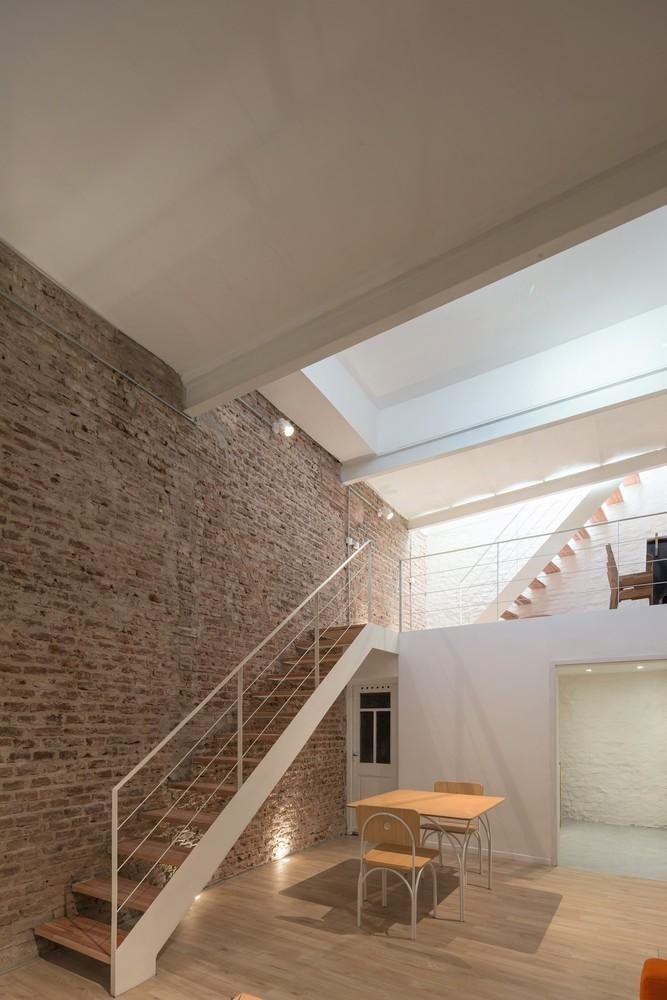 Ở tầng trệt, lớp vữa được cạo sạch để lộ phần tường gạch thô, tạo điểm nhấn cho ngôi nhà, đây là nơi tích hợp giữa phòng ăn, phòng ngủ, phòng tắm và nhà vệ sinh. Tầng trệt còn được bố trí một bộ sô pha để gia chủ tiếp khách