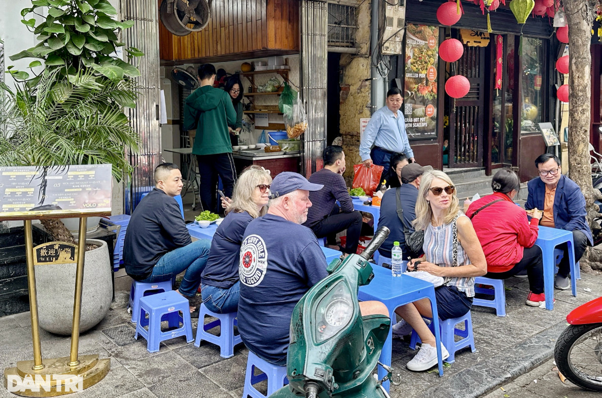 Thực khách nước ngoài ngồi tràn ra vỉa hè, chủ quán mỏi miệng hô "hết bàn rồi" (Ảnh: Thanh Thúy).