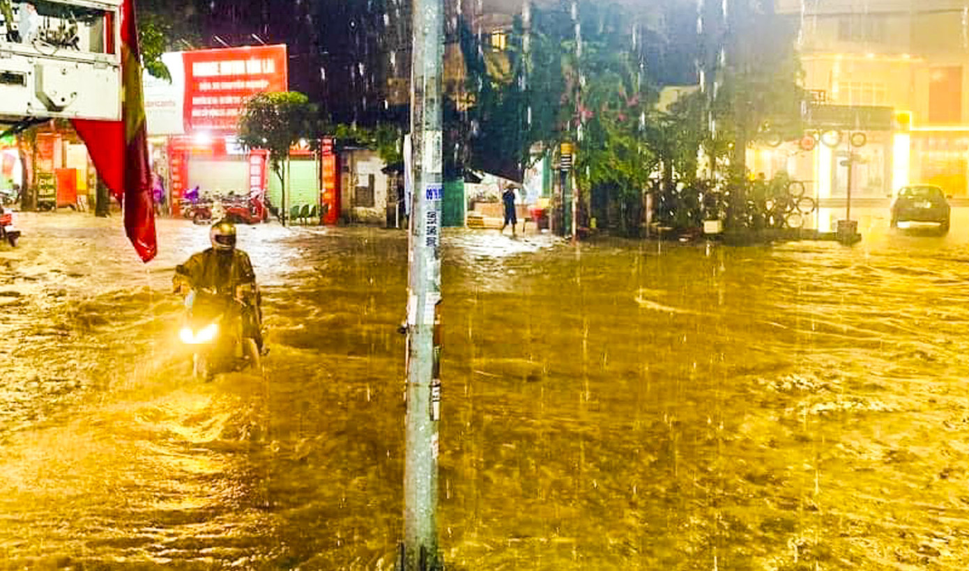 Mưa lớn khiến người dân di chuyển rất khó khăn. Ảnh: Vân Trường.