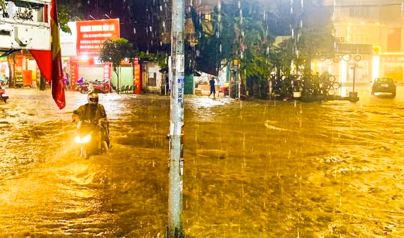Mưa lớn khiến người dân di chuyển rất khó khăn. Ảnh: Vân Trường.
