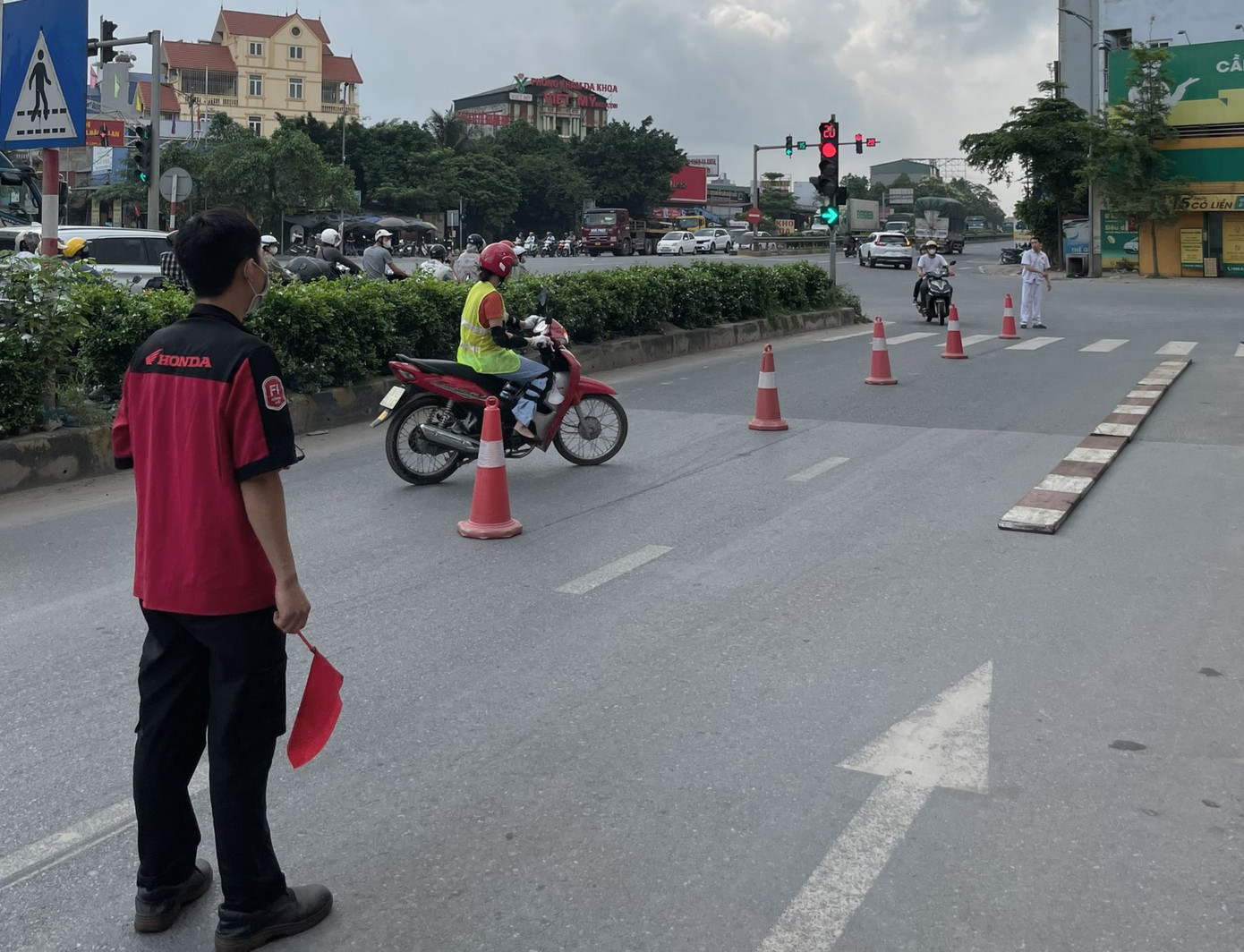 Phía ngoài, các cô gái vẫn tự tin khi tham gia thực hành đi xe zích zắc theo cọc tiêu.