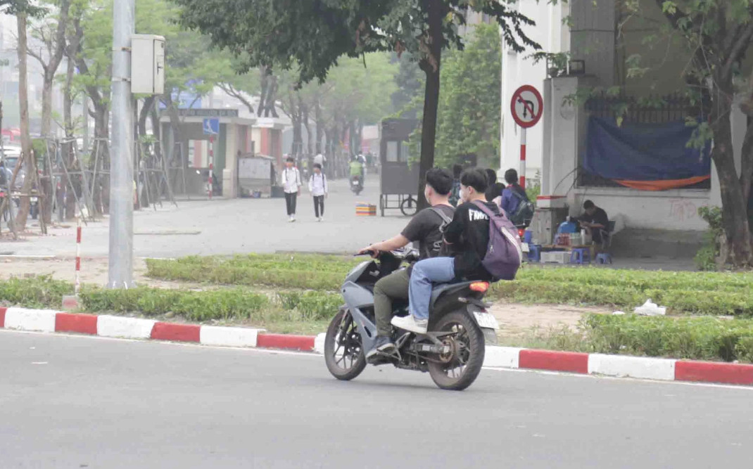 Một trường hợp sinh viên đi xe máy chở 2 không đội mũ bảo hiểm, bỏ chạy khi thấy CSGT (Ảnh: Trần Thanh).