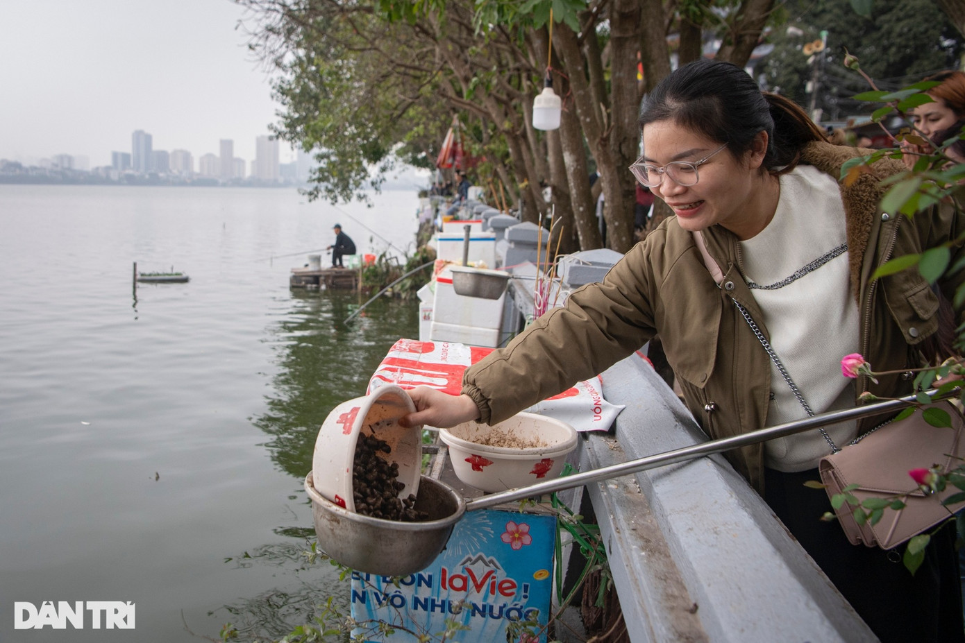 Nhiều người giữ phong tục phóng sinh lấy may đầu năm, thả các loại ốc, cá xuống hồ Tây.