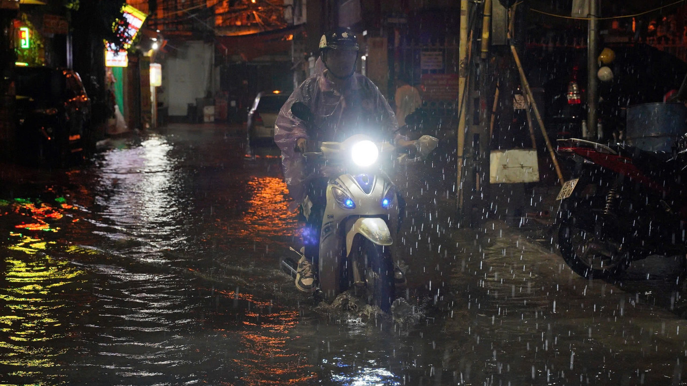 Nhiều xe máy liều mình vượt qua "biển nước" trên đường Trần Bính Nhiều xe máy liều mình vượt qua "biển nước" trên đường Trần Bính