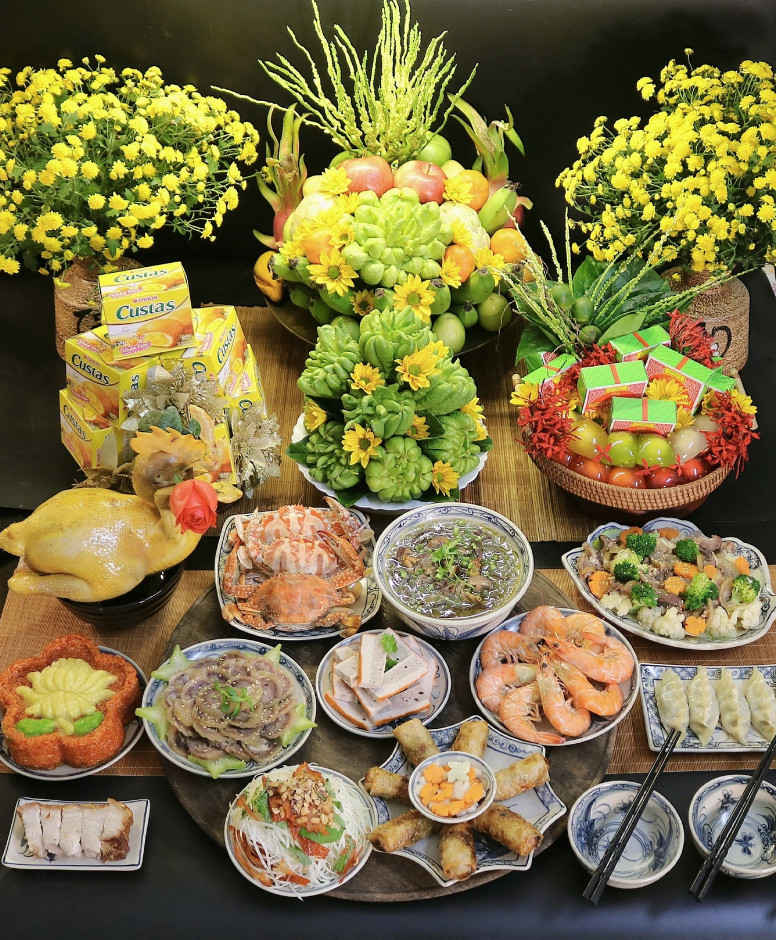 Mâm cỗ mùng 1/11 Âm lịch gồm gà luộc cánh tiên, xôi gấc, tôm ghẹ hấp, thịt bê cuộn gừng, chả quế, nem rán, nộm đu đủ, canh miến nấu lòng gà, thịt bê xào thập cẩm, bánh nếp nhân tôm thịt, thịt quay giòn bì.