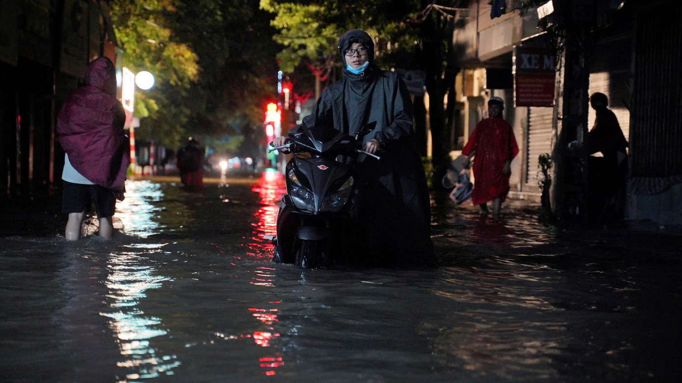 Nhiều xe máy liều mình vượt qua "biển nước" trên đường Trần Bính Nhiều xe máy liều mình vượt qua "biển nước" trên đường Trần Bính