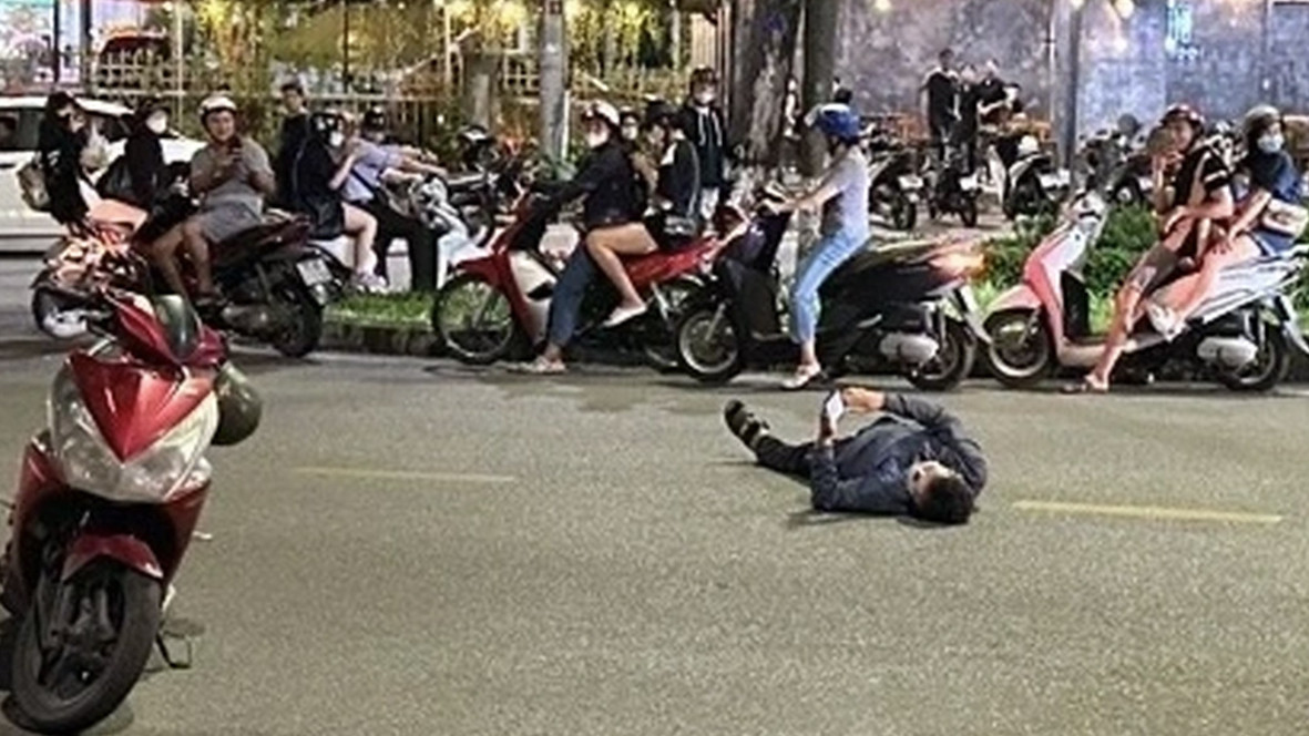 Người đàn ông say xỉn, "nằm vạ" giữa đường và bấm điện thoại khi bị yêu cầu đo nồng độ cồn. Ảnh: Bạn đọc cung cấp. Người đàn ông say xỉn, "nằm vạ" giữa đường và bấm điện thoại khi bị yêu cầu đo nồng độ cồn. Ảnh: Bạn đọc cung cấp.