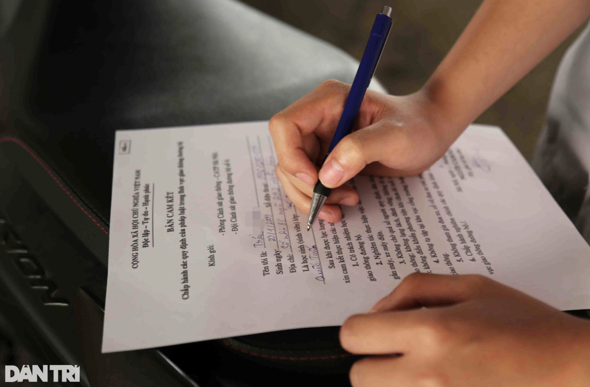 CSGT yêu cầu các trường hợp học sinh viết bản cam kết không tái phạm (Ảnh: Trần Thanh).