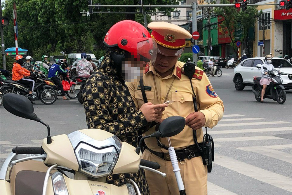 Lực lượng CSGT hướng dẫn cho tài xế xuất trình giấy tờ liên quan đến người và phương tiện qua VNeID. Ảnh: CACC