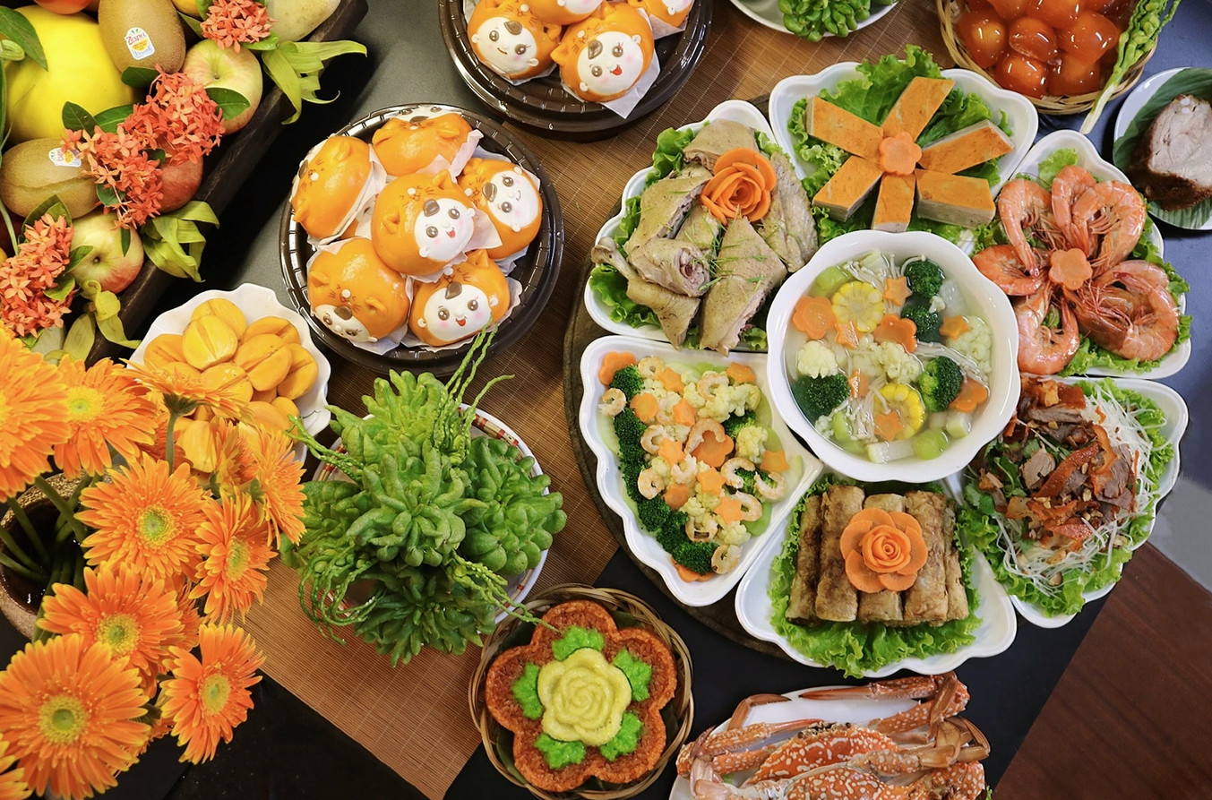 Mâm cúng có sắc cam chủ đạo với xôi gấc, gà ta, chả quế, tôm hấp, nộm đu đủ, ghẹ hấp, thịt quay giòn bì, canh rau củ nấu nước gà.