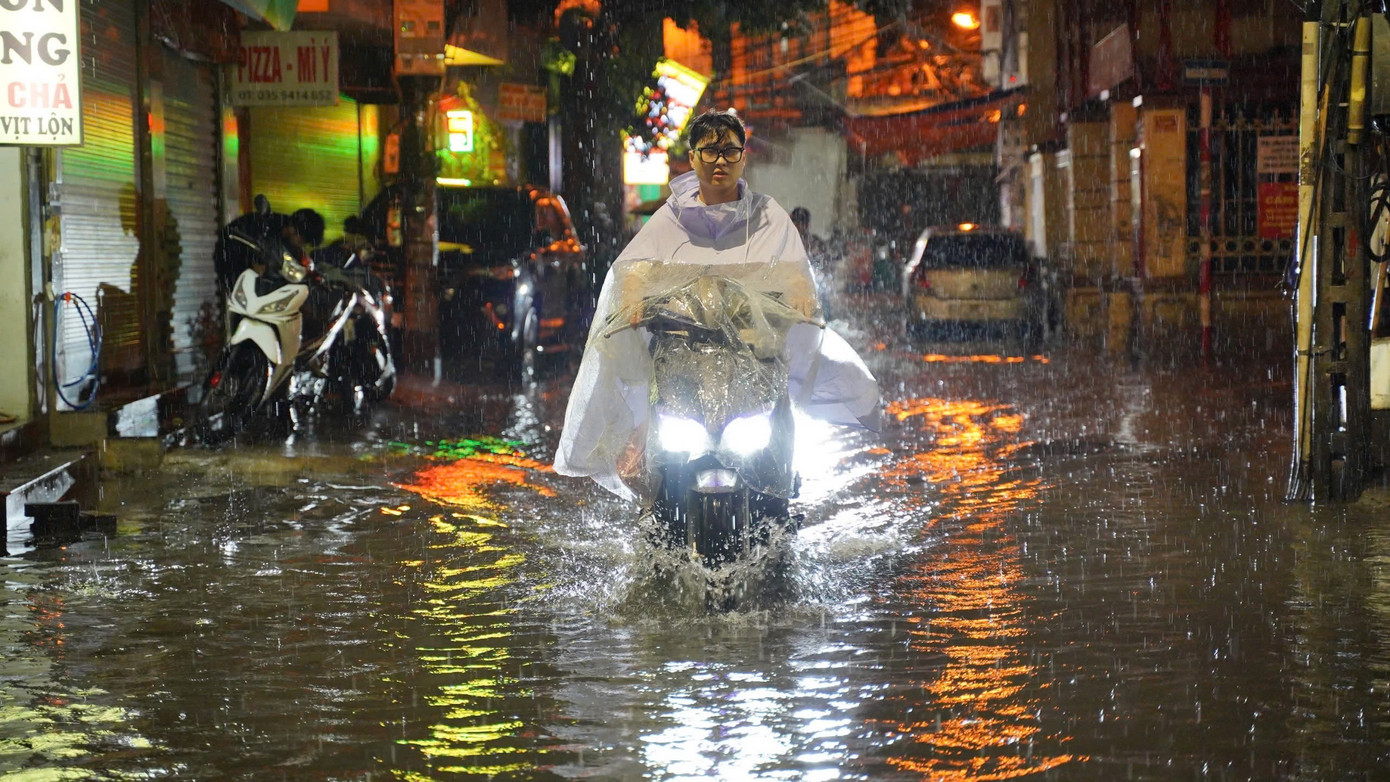 Nhiều xe máy liều mình vượt qua "biển nước" trên đường Trần Bính Nhiều xe máy liều mình vượt qua "biển nước" trên đường Trần Bính