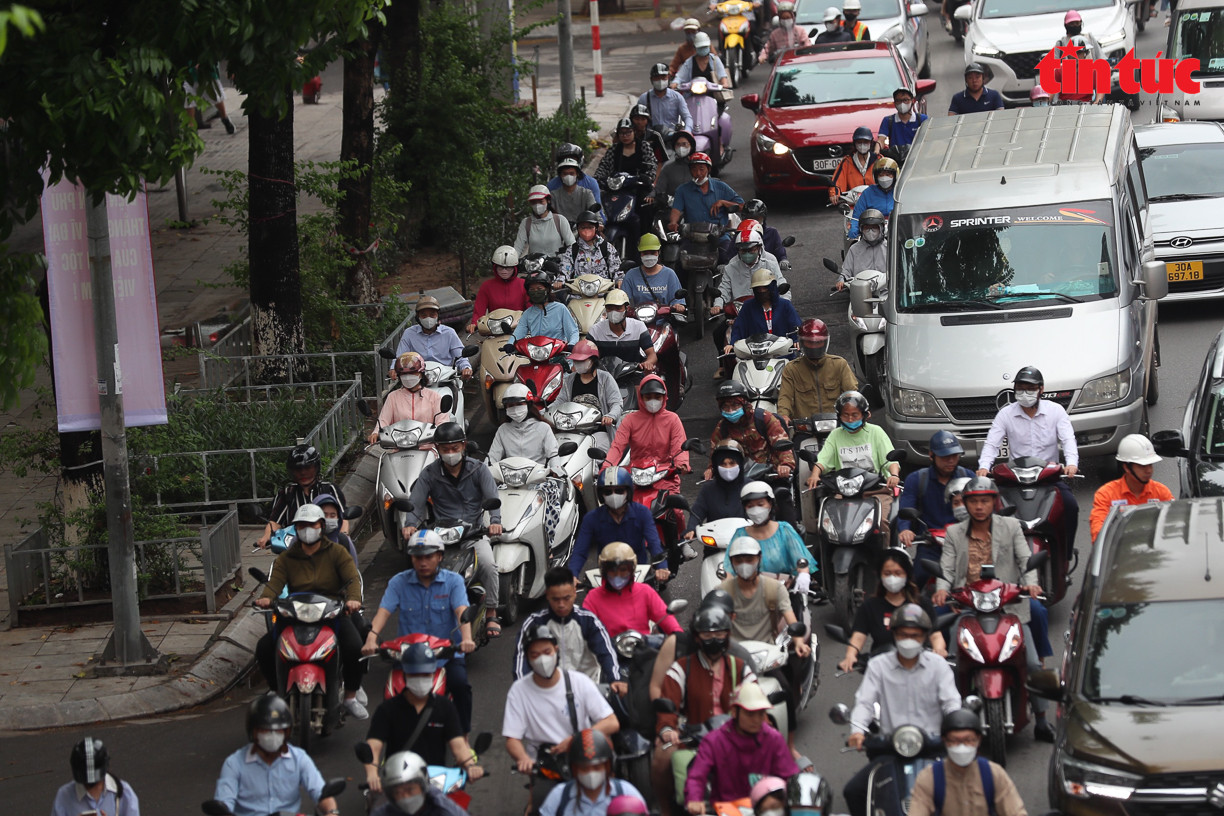 Xe máy và ô tô chen nhau trên đường.